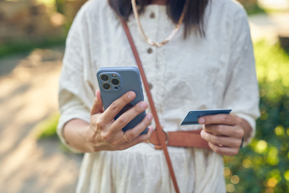 Kvinna som håller i en mobil och betalkort